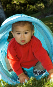 Toddler playing outside in tunnel